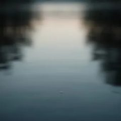 Ein Wassertropfen über stillem See