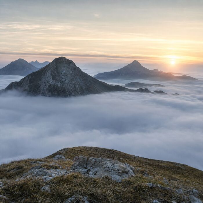 Berggipfel über einem Nebelmeer im Sonnenaufgang